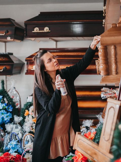 Eine Frau zeigt ein Foto, um einen Sarg zu verkaufen und Geld zu verdienen