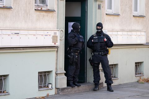 Polizisten stehen während einer Razzia gegen mutmaßliche Rechtsextreme in einem Hauseingang im Dresdner Stadtteil Cotta
