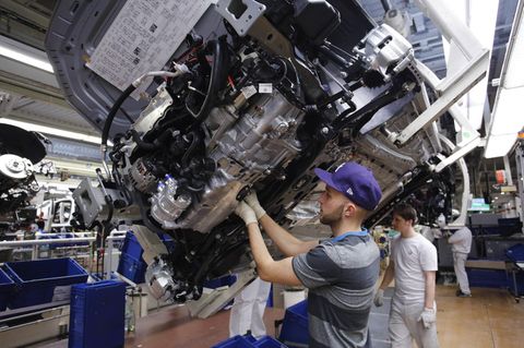 Ein Mann arbeitet am Fließband in einem VW-Werk
