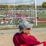 Menschen schauen auch von außerhalb von den Parkplätzen aus bei dem Footballspiel zu