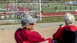 Menschen schauen auch von außerhalb von den Parkplätzen aus bei dem Footballspiel zu