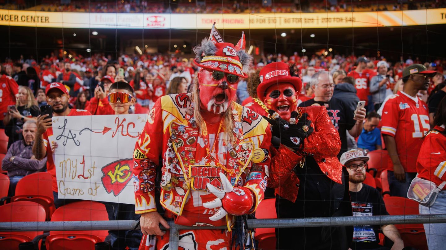 Fans posieren in den Fanrängen beim Football- Spiel