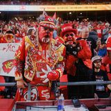 Fans posieren in den Fanrängen beim Football- Spiel