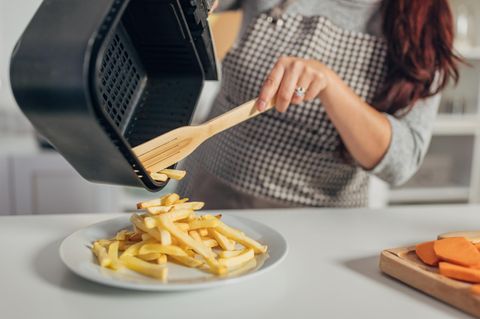 Hispanoamerikanerin macht Pommes frites in der Heißluftfritteuse