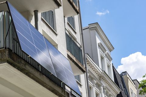 Solarmodul am Balkongeländer eines Altbaus installiert – mit einem Salzwasserspeicher für Balkonkraftwerke Energie speichern.