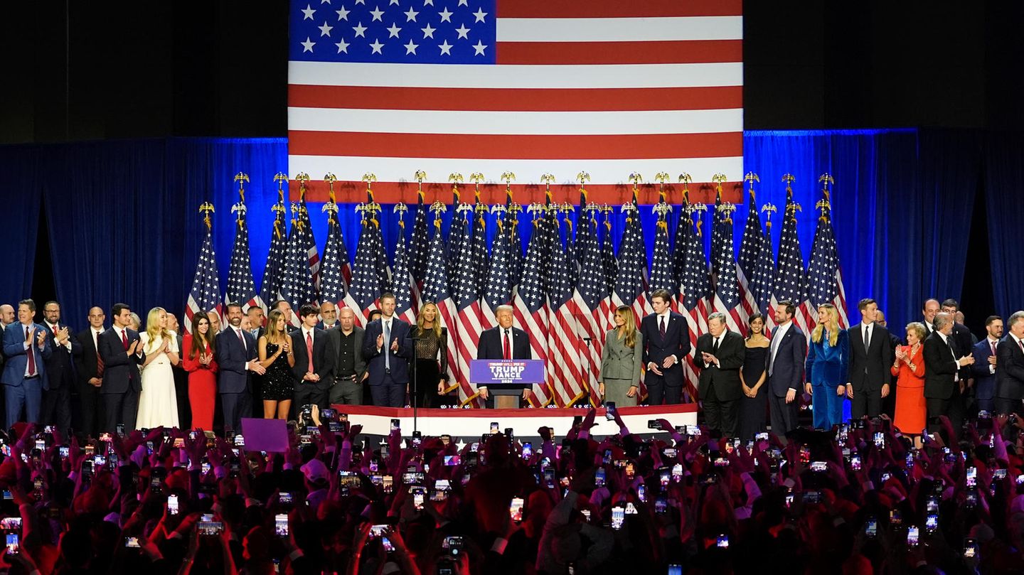Donald Trump steht mit seiner gesamten Entourage auf der Bühne.