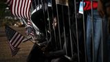 Noch schwenkt sie die US-Flagge, ihr Blick ist aber schon leer