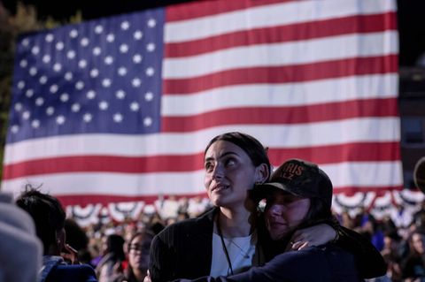 Wähler bei der US-Wahl vor einer Landesflagge