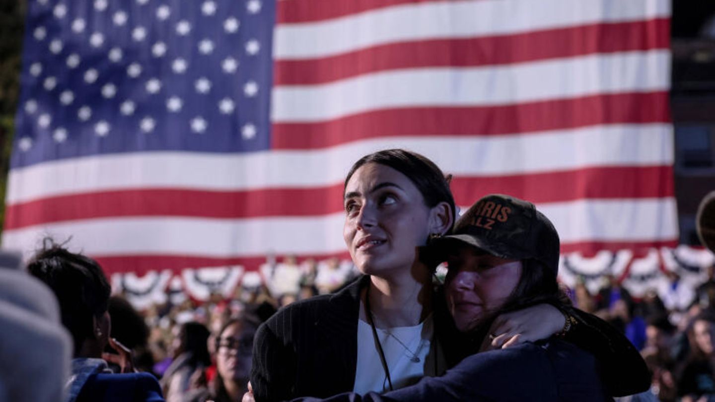 Wähler bei der US-Wahl vor einer Landesflagge