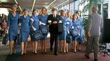 Leonardi DiCaprio als Flugkapitän mit Stewardessen in blauen Kostümen