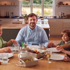 Eine Familie betet am Tisch