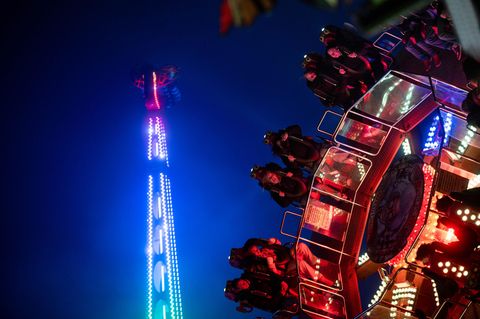 Beleuchtete Fahrgeschäfte auf der Allerheiligenkirmes in Soest bei Dunkelheit