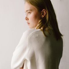 Eine Frau, in weichem Licht, die aus dem Fenster guckt