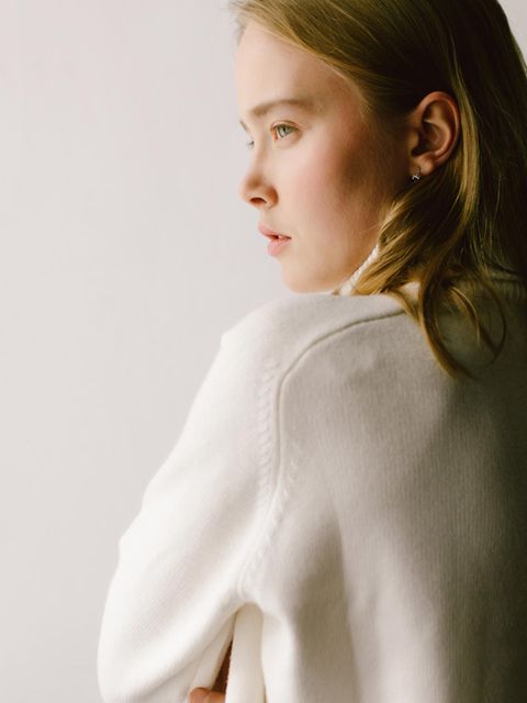 Eine Frau, in weichem Licht, die aus dem Fenster guckt