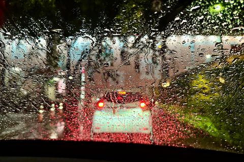 Verschwommenes Auto bei Nacht und Regen