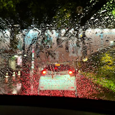 Verschwommenes Auto bei Nacht und Regen