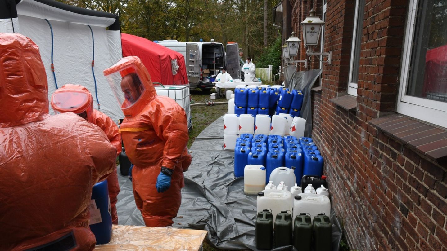 Polizisten in Schutzanzügen holen große Mengen Chemikalien in Kanistern aus einem Drogenlabor