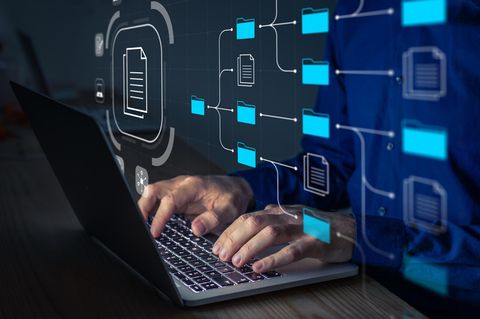 Hände tippen am Laptop, darüber eine Illustration von Ordnern und Datentranfer