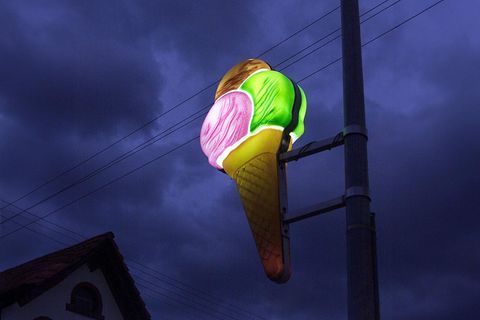 Eine leuchtende Eisdielen Reklame vor bewölktem Nachthimmel