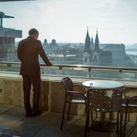 Olaf Scholz steht auf einem Balkon und schaut auf Budapest