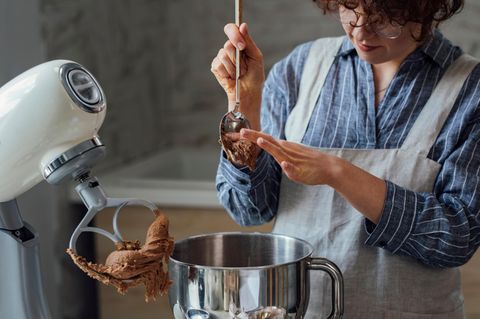 Frau arbeitet mit einer Multifunktions-Küchenmaschine.