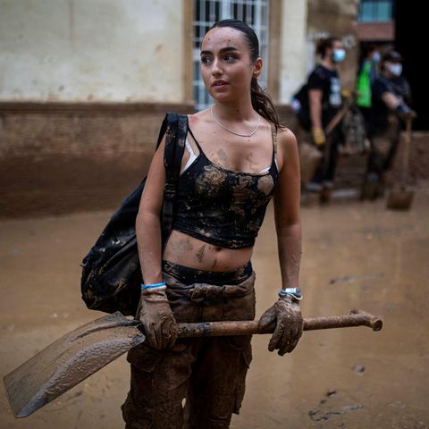 Klimaschützerin mit Schaufel bei Aufräumarbeiten in Spanien