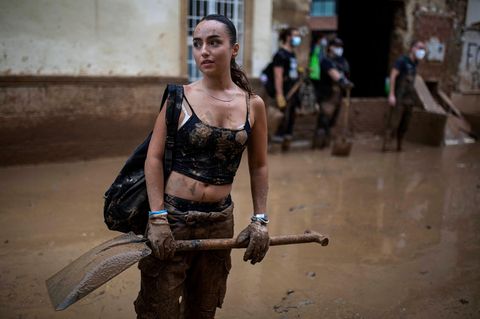 Klimaschutz Frau mit Schaufel bei Aufräumarbeiten in Spanien