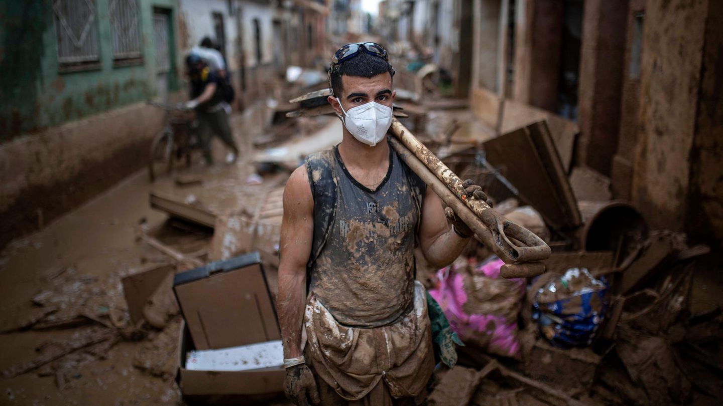 Klimaschutz-Mann mit Schaufel bei Aufräumarbeiten in Spanien