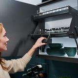 Liftsysteme für Küchenhochschränke   Wenn mit 70+ die Beweglichkeit und Kraft nachlässt, werden Hochschränke in der Küche zum Sicherheitsrisiko. Warum also nicht den Schrankinhalt zu sich herunterziehen? Genau das macht der Hochschrankeinsatz iMove von Kesseböhmer. Über ein Federsystem können so mit einer Hand bis zu acht Kilo bewegt werden. 