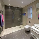 Barrierefreie Dusche rein, Badewanne raus  Im Bad gilt es, jede Stolperfalle zu eliminieren. Es sollte tatsächlich barrierefrei statt nur barrierearm sein. Die klassische Duschtasse mit ihrem Absatz muss daher einer begehbaren, ebenerdigen Dusche weichen. Wenn die Platzverhältnisse es zulassen, sollte die Grundfläche 120 x 120 Zentimeter betragen, damit im Fall der Fälle auch noch ein Duschhocker Platz findet.  Die Duschtür sollte nach innen aufgehen, noch besser ist eine Schiebe- oder Falttür. Beides gibt es aus Glas. Eine größere Dusche ist altersgerechter als eine Badewanne, deren hoher Einstieg im Alter stets ein Unfallrisiko darstellt. Wenn es im Bad an Platz mangelt, sollte die Wanne daher raus und der Raum für eine größere Dusche genutzt werden. Haltegriffe in der Dusche sind selbstverständlich. Im Sanitärhandel gibt es Duscharmaturen mit integrierten Haltegriffen, die deutlich schicker aussehen als die üblichen Plastikhalterungen.