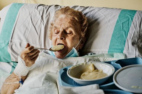 alte Frau isst Krankenhausessen