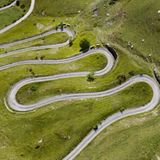 Grüne Wiese mit engen Serpentinen aus der Luft am Alpenpass Colle Valcavera