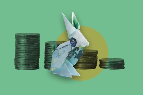 Diese Illustration zur Inflation zeigt einen gefalteten Origamihasen aus einem Geldschein vor Münzstapeln