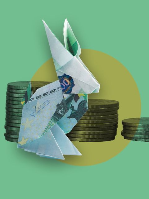 Diese Illustration zur Inflation zeigt einen gefalteten Origamihasen aus einem Geldschein vor Münzstapeln