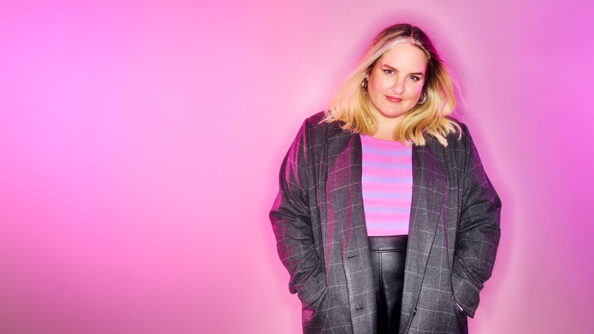 Gulia Becker steht vor einem pinken Hintergrund. Gulia Becker steht vor einem pinken Hintergrund.