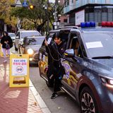 Eine Schülerin steigt vor einer Aufnahmeprüfung aus einem Polizeifahrzeug