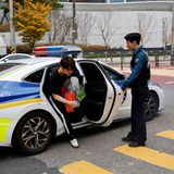 Einem Schüler wird von einem Polizist die Tür aufgehalten nachdem dieser ihn zur Schule zu einer wichtigen ÜPrüdung gebracht hat