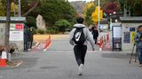 Kurz vor Prüfungsbeginn rennt ein Schüler auf das sich gerade schließende Schultor zu