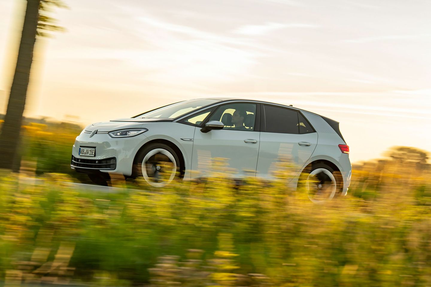 Eines der beliebtesten E-Autos von VW, Typ ID.3, fährt an Rapsfeldern vorbei