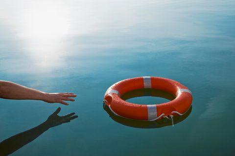 Eine Hand greift nach einem Rettungsring. Ausweg aus der Krise?