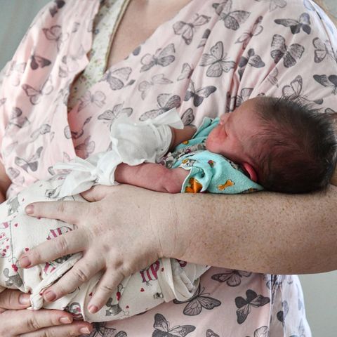 A newborn rests in his mother's arms at a perinatal center in Chita, Russia