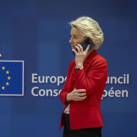 Vor einer blauen Wand mit Aufschrift "European Council" ("Rat der EU") steht Ursula von der Leyen und telefoniert – mit Pfizer?