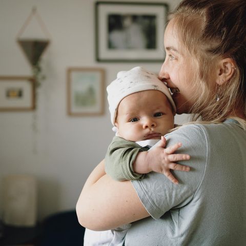 Eine Frau hält ein Neugeborenes, Bebilderung zum Thema Mutterschaft
