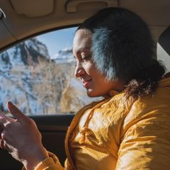 Frau sitzt im Winter im Auto