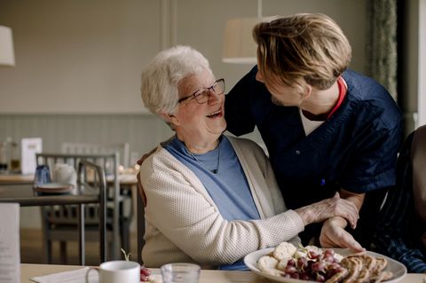 Pflegeversicherung: Eine ältere Dame mit einer Pflegerin im Seniorenheim