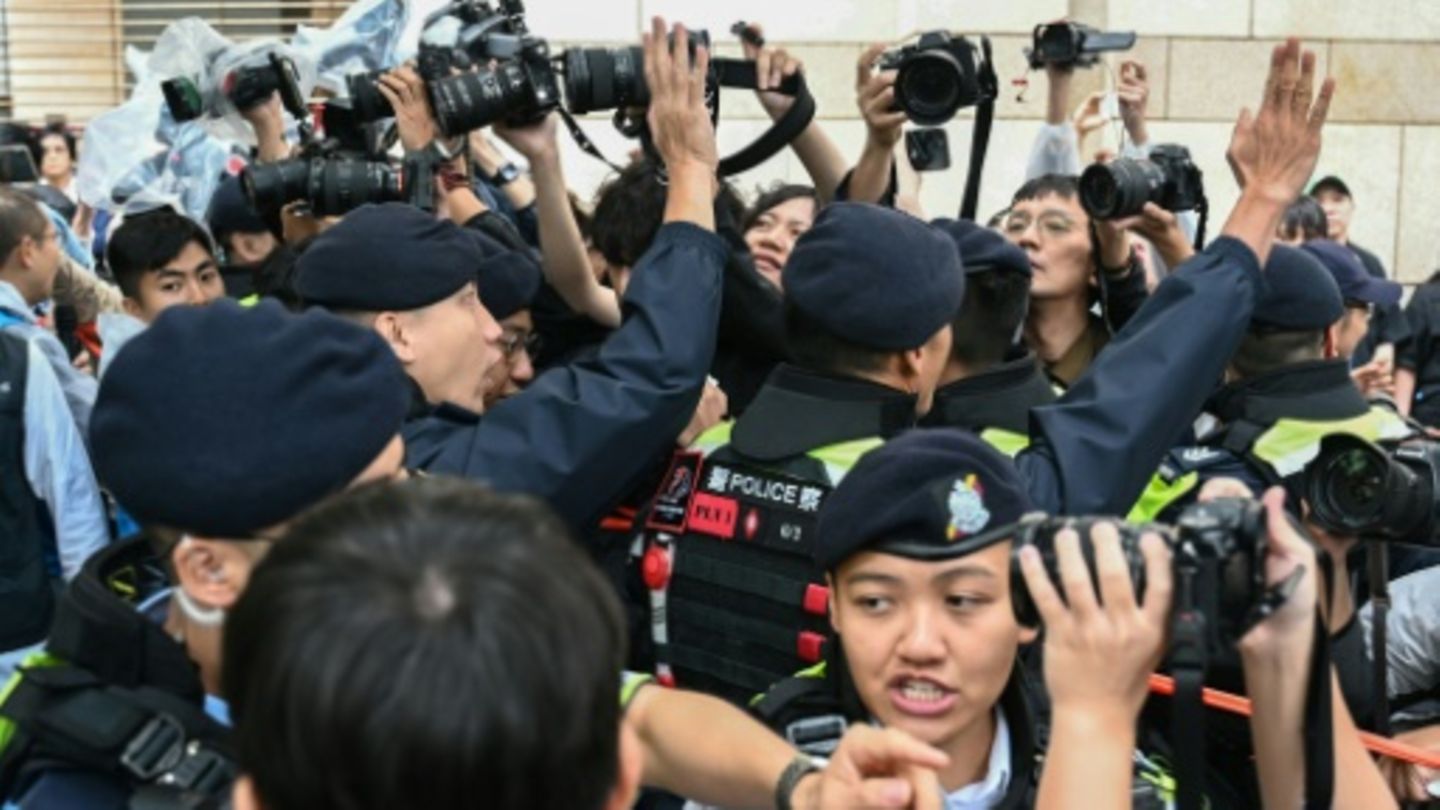 Polizisten halten Journalisten vor dem Gericht in Hongkong zurück