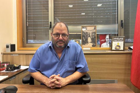 Ofer Cassif in seinem Büro in Israels Parlament, der Knesset. Im seinem Büro steht die rote Flagge des Kommunismus sowie Figuren und Bilder von linken Anführern wie Karl Marx, Che Guevara und Rosa Luxemburg.        