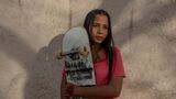 Asha Gond mit ihrem Skateboard in der Hand
