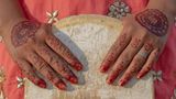 Asha mit traditioneller Henna-Bemalung auf ihren Händen, während sie ihr Skateboard hält
