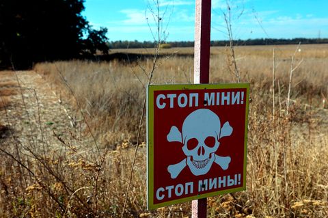 Ein Warnschild "Stop! Minen" in der Region Charkiw, Ukraine
